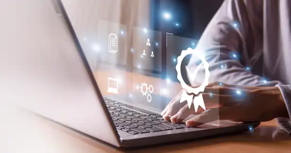 Manos tecleando en un portátil con un icono de certificado digital