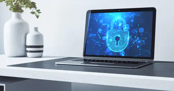 Portátil con un candado de seguridad en pantalla sobre una mesa blanca