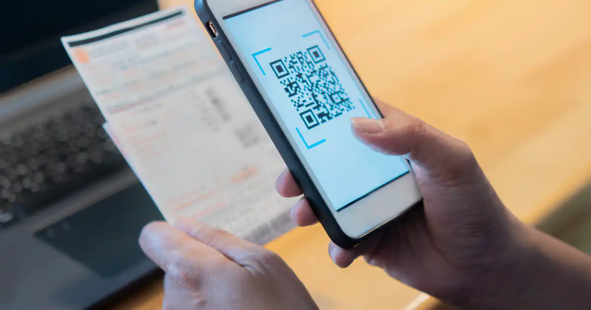 Móvil escaneando el código QR de una factura impresa