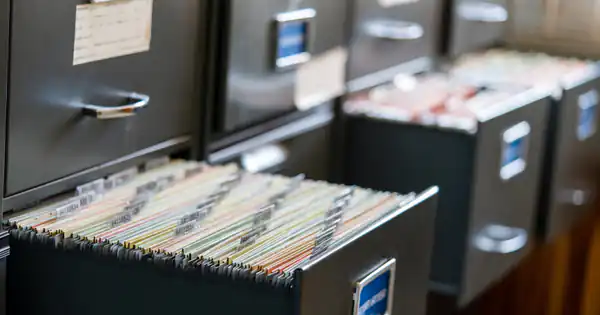 Cajón de archivador abierto lleno de carpetas colgantes de colores