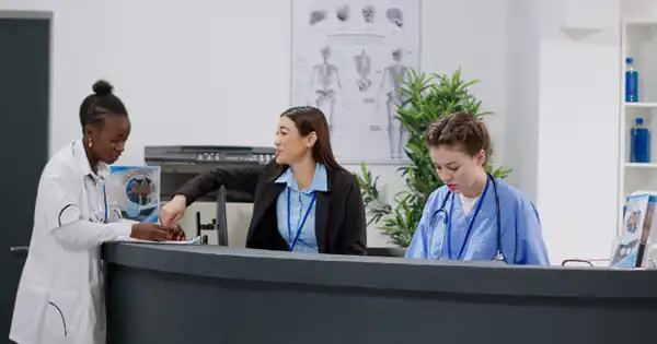 Personal sanitario y administrativo en el mostrador de recepción de una clínica