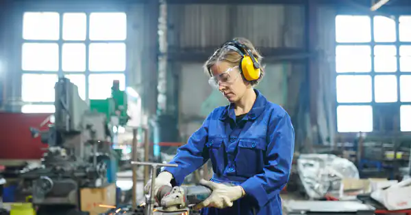 Operaria con protección auditiva trabajando en un taller industrial