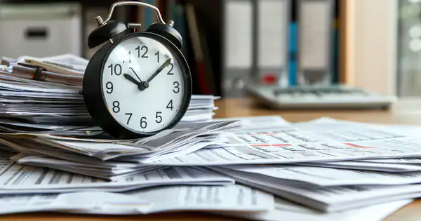 Reloj despertador sobre una pila de documentos de oficina
