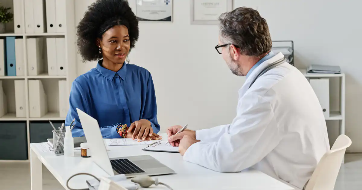 Médico atendiendo a una paciente en su consulta