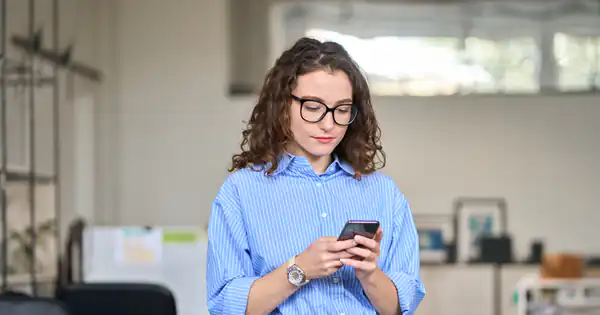 Trabajadora consultando su móvil en la oficina