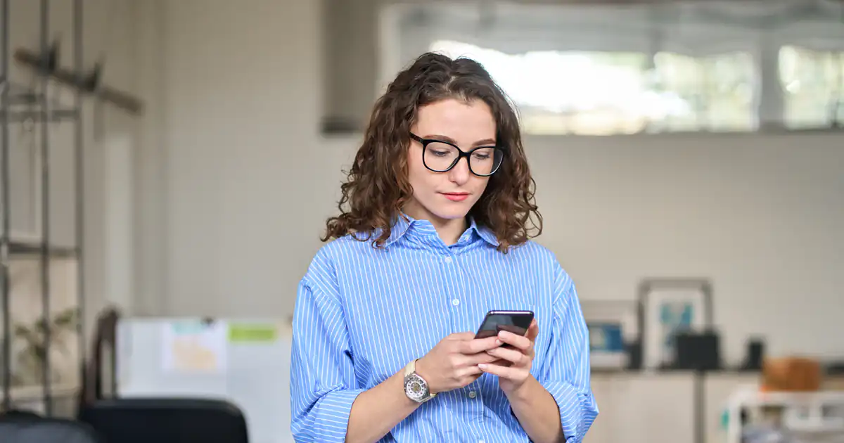Trabajadora consultando su móvil en la oficina