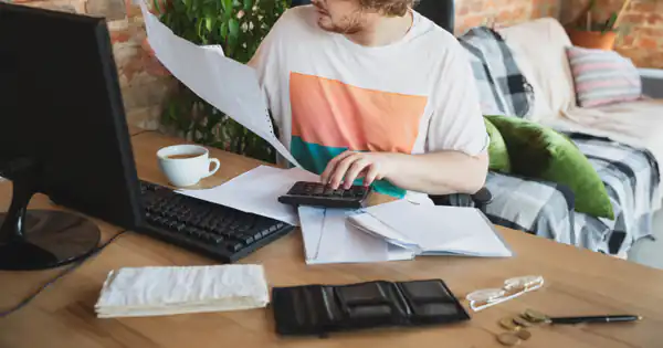 Autónomo revisando tickets y gastos frente al ordenador en casa
