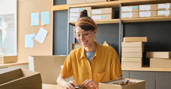 Emprendedora preparando un pedido en cajas de cartón para enviar