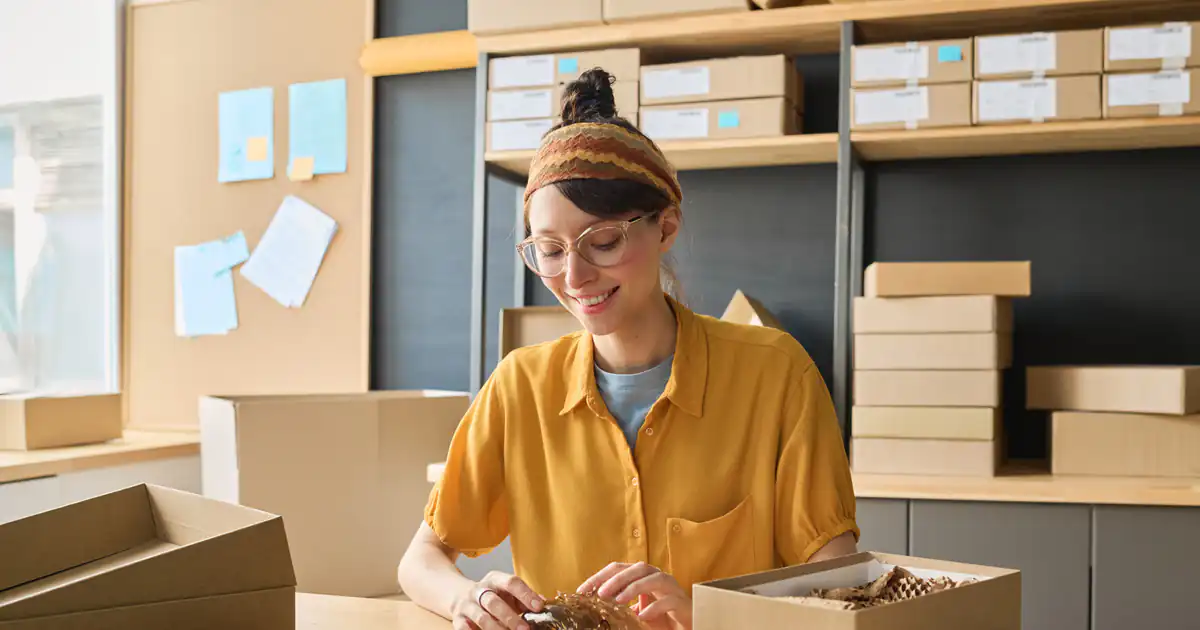 Emprendedora preparando un pedido en cajas de cartón para enviar
