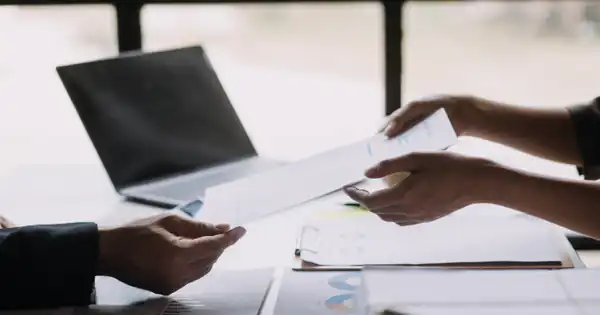 Profesionales intercambiando documentos sobre una mesa de oficina