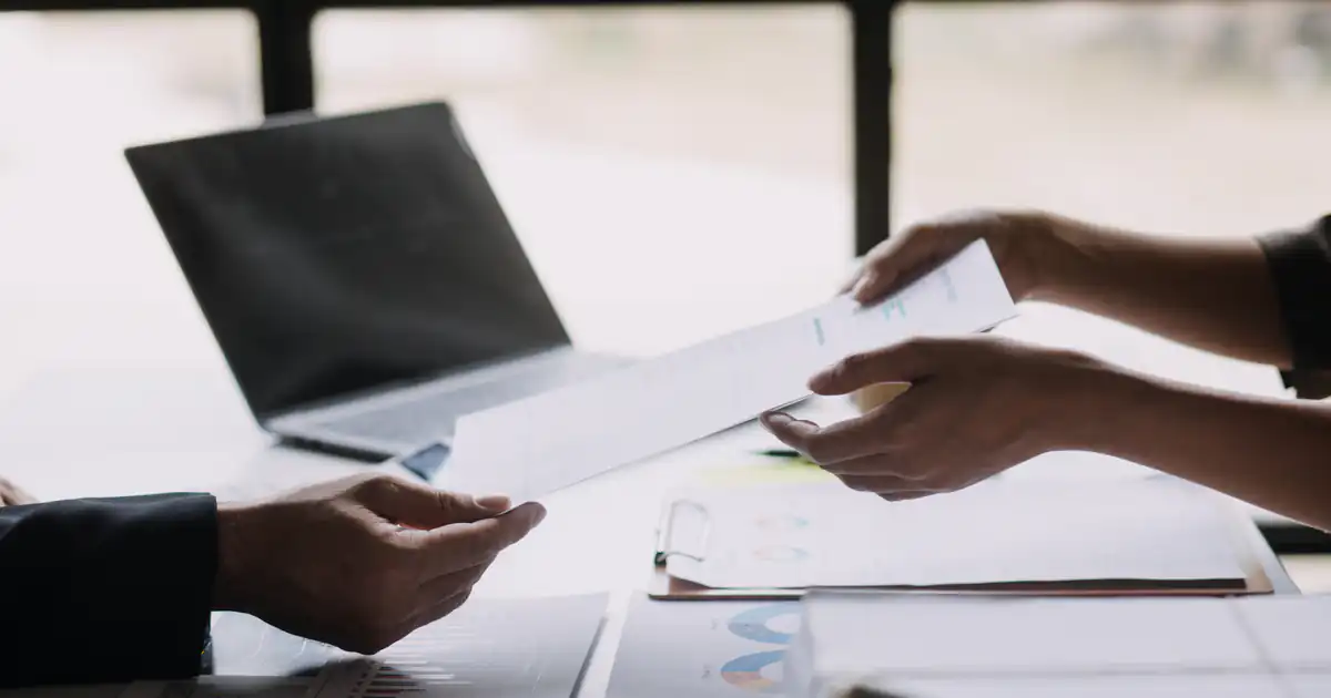 Profesionales intercambiando documentos sobre una mesa de oficina