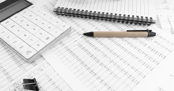Hojas de cálculo impresas con calculadora, bolígrafo y cuaderno