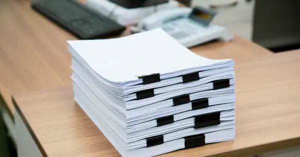 Montón de documentos sujetos con pinzas sobre una mesa