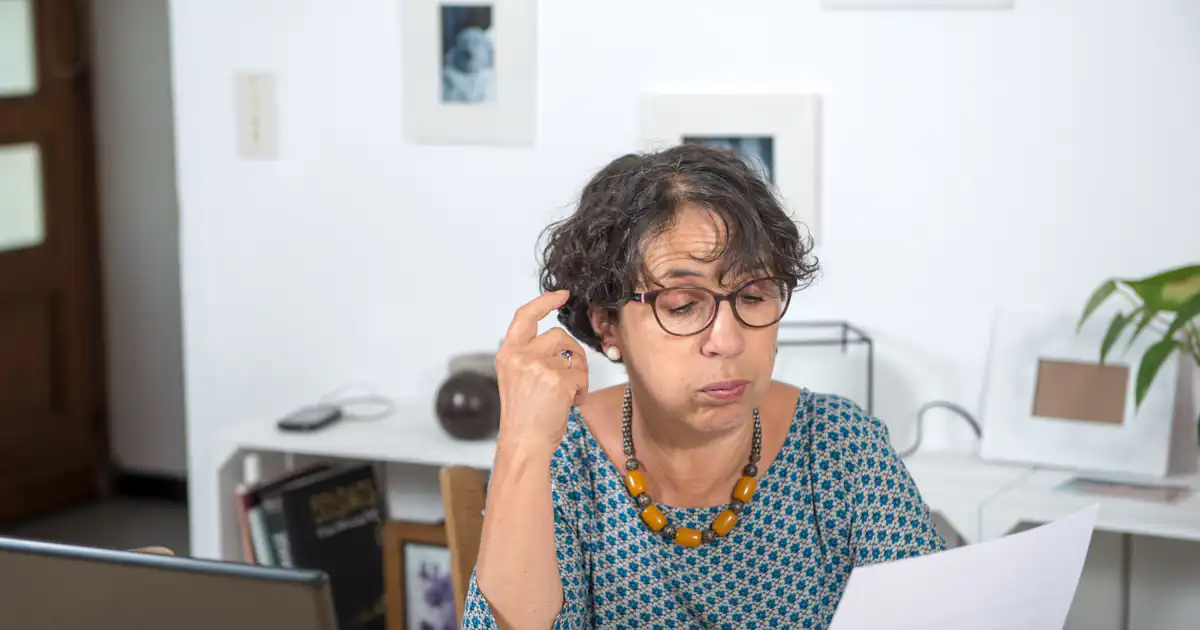 Empresaria preocupada leyendo una factura pendiente en su despacho