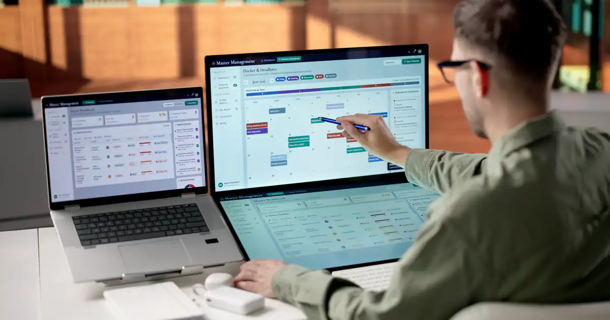 Empleado revisando un calendario de horarios en dos pantallas
